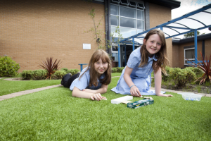 Children at Westfield School relaxing on the LazyLawn artificial grass